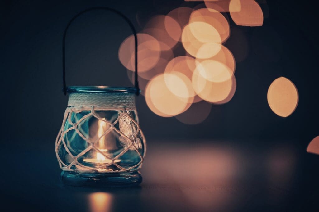Blue glass holding a candle creating soft light spots in the background