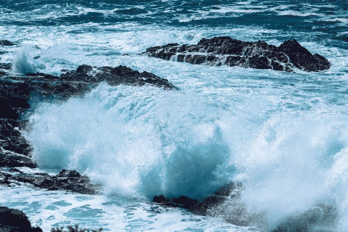 Powerful ocean waves crashing against dark coastal rocks