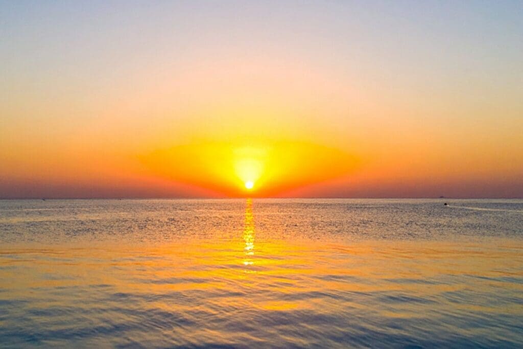 Sunset over the ocean with soft light reflecting on the water